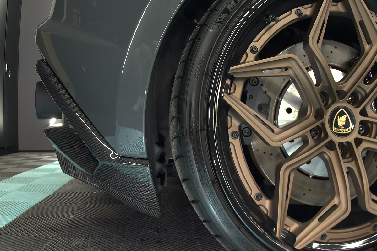 Carbon-Splitter an der Seite eines Lamborghini, daneben das Rad