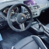 Hochwertiges BMW Cockpit mit Carbon-Details und sportlichem Lenkrad für optimale Fahrzeugperformance.