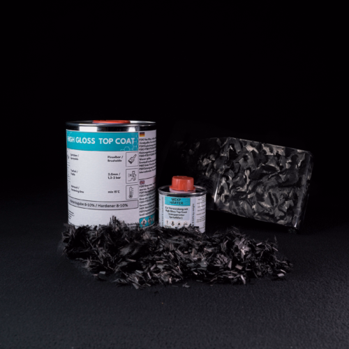 Forged Carbon Set (schwarzer Hintergrund) mit geschnittenen forged carbon Fasern im Vordergrund und einer Musterplatte im Hintergrund