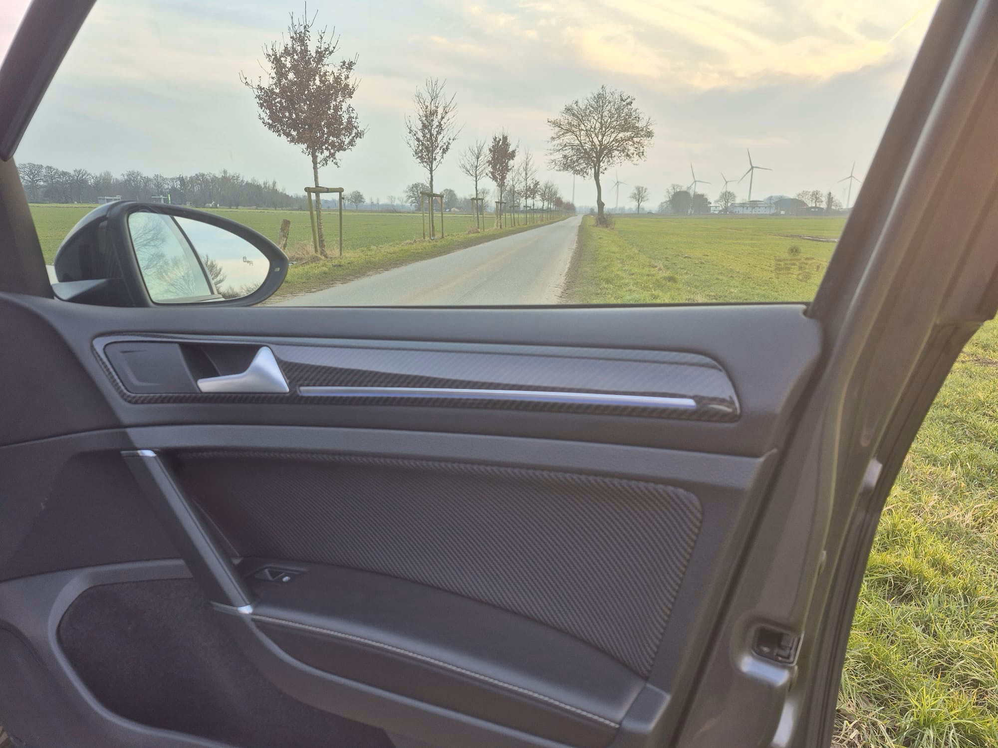 Reflektierende Kohlefaser-Auto-TĂĽrverkleidung, sportliches Autoinnenraum-Design, nachhaltiger Fahrzeug-Modifikationsstil.