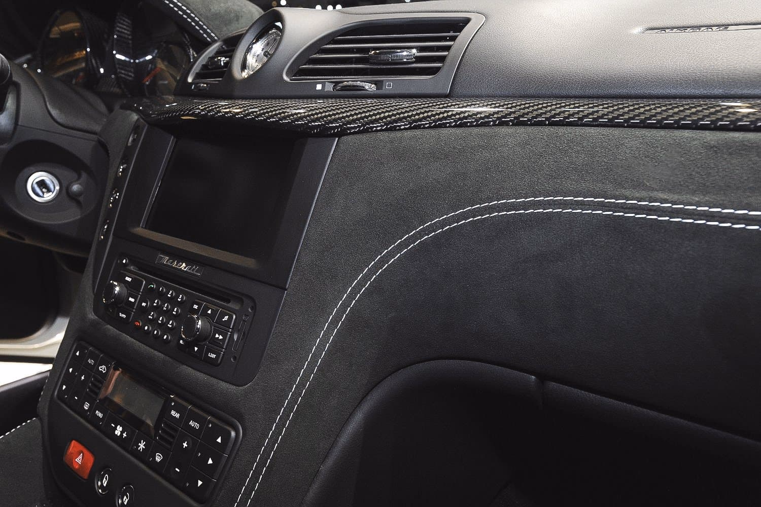 Hochwertiges Carbon-Finish im Armaturenbereich eines Maserati Fahrzeugs.