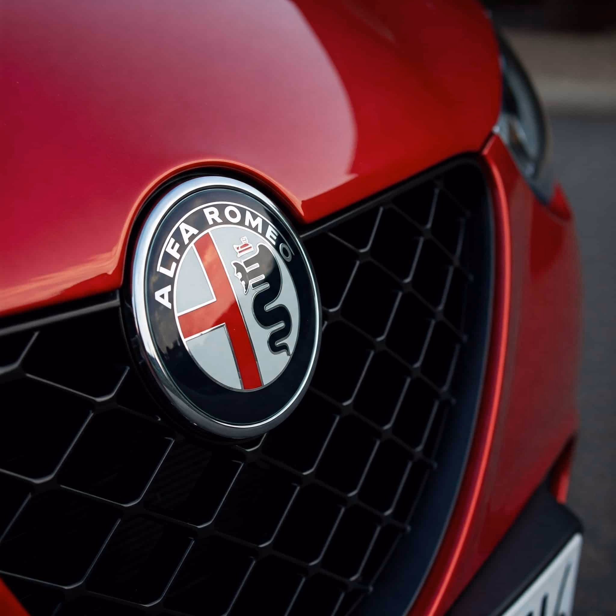 SICHTBAR: Alfa Romeo Logo auf rotem Fahrzeug, Hochwertige Autoveredelung, Carbon Modifikationen, sportliches Design, exklusive Fahrzeugästhetik, Auto-Tuning.