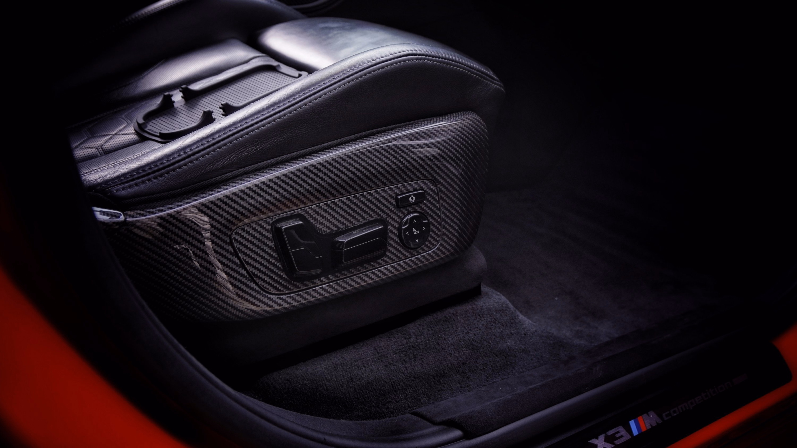 Schwarze Carbon-Folienveredelung fĂĽr Autositzverstellung und Inneneinrichtung.