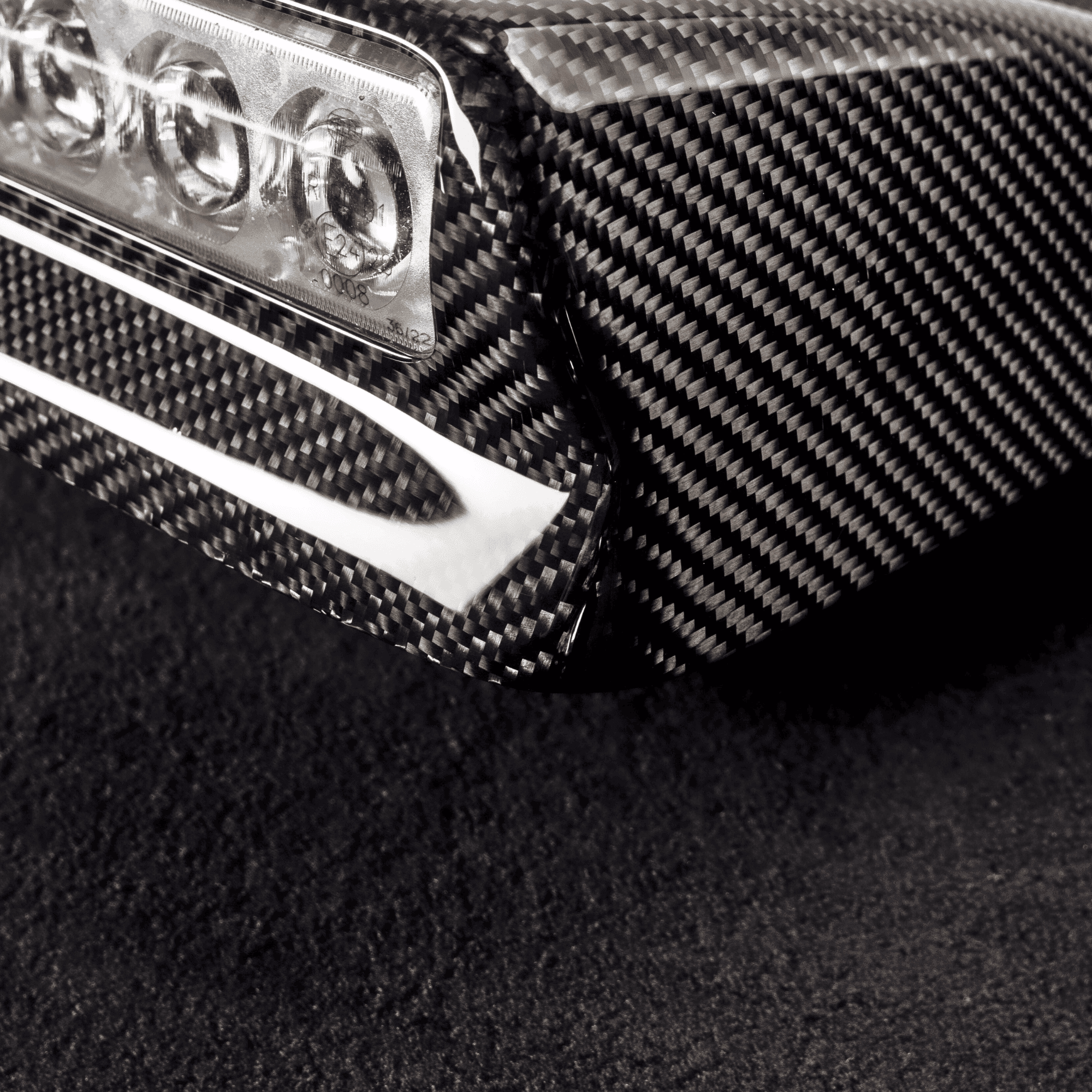 Hochwertiger Carbon-Faser-Teil mit Carbon Modifications Logo für individuelle Fahrzeugästhetik.